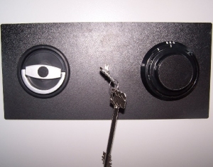 Widok zamknięcia w szafie metalowej. Okrągła klamka uruchamiająca układ rygli ruchomych oraz 2 zamki: kluczowy oraz szyfrowy mechaniczny.